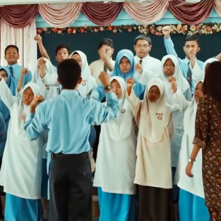 The choral speaking students with their arms raised, Zidane and Cikgu Cheryl in front of them - Adiwiraku